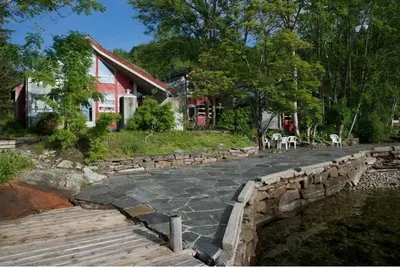a house with a stone walkway next to a house at Hardanger Feriesenter Nesvika in Norheimsund