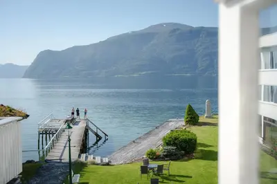 people standing on a dock in the water at Leikanger Fjordhotel - Unike Hoteller in Leikanger