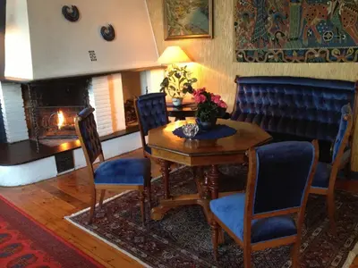 a dining room with a table and chairs and a fireplace at Leikanger Fjordhotel - Unike Hoteller in Leikanger
