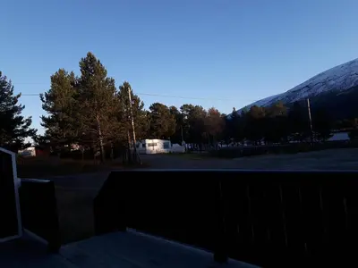 a view of a parking lot with a snow covered mountain at Lesjaskogsvatnet Camping in Lesjaskog
