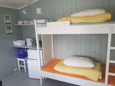 a room with two bunk beds and a kitchen at Lesjaskogsvatnet Camping in Lesjaskog