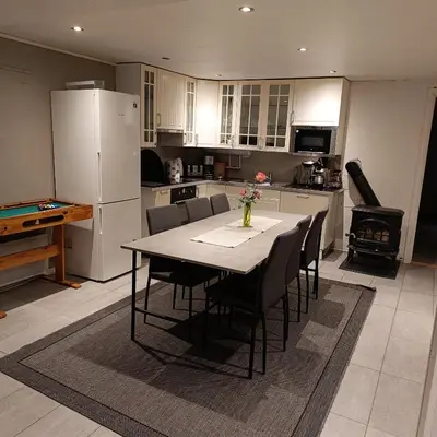 a kitchen with a table and chairs and a kitchen with a refrigerator at Malvik, Hundhamaren, Trondheim in Malvik