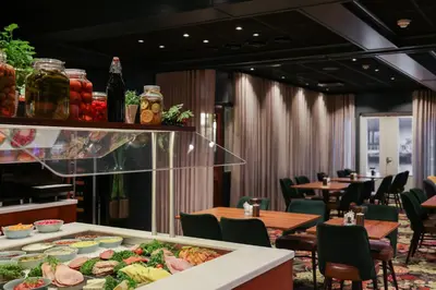 a restaurant with tables and chairs and food on a counter at Quality Hotel Florø in Florø