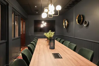 a conference room with a wooden table and green chairs at Quality Hotel Florø in Florø