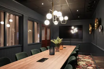 a conference room with a wooden table and green chairs at Quality Hotel Florø in Florø