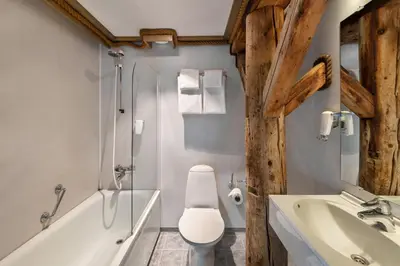 a bathroom with a toilet and a tub and a sink at Quality Hotel Florø in Florø