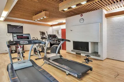 a gym with bikes and a treadmill and a fireplace at Nordfjord Hotell in Nordfjordeid