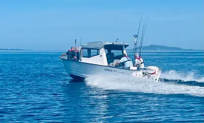 a boat in the water with two people on it at Awesome Fishing, Boating and Nature Experience at Fiskesenter Birkeland in Rekdal