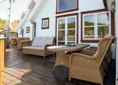 a patio with a table and chairs on a house at Eastside Cottages in Bømlo
