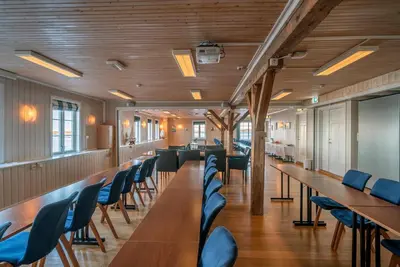 a conference room with wooden tables and blue chairs at Finnøy Bryggehotell - by Classic Norway Hotels in Finnøy