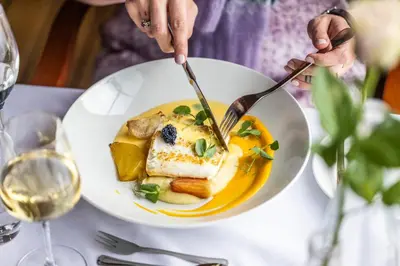 a person eating a plate of food on a table at Finnøy Bryggehotell - by Classic Norway Hotels in Finnøy