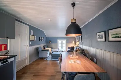 a kitchen and dining room with a wooden table in a room at Ona Havstuer - by Classic Norway Hotels in Ona