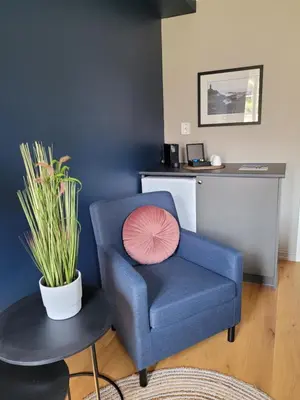 a blue chair with a pink pillow in a room at Ona Havstuer - by Classic Norway Hotels in Ona