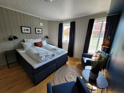 a bedroom with a bed and a couch and a chair at Ona Havstuer - by Classic Norway Hotels in Ona