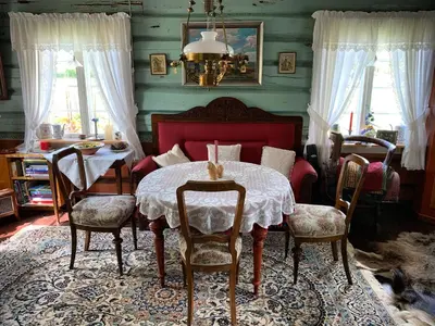a bedroom with a table with chairs and a bed at Kvebergsøya Gard in Grimsbu