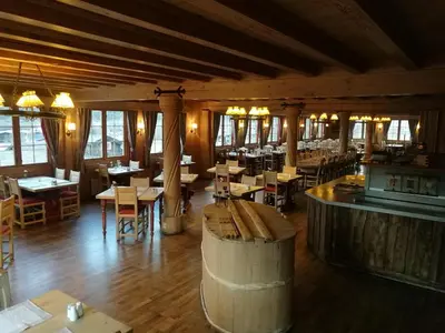 a restaurant with a barrel room with tables and a bar at Fossheim Hotel Lom in Lom