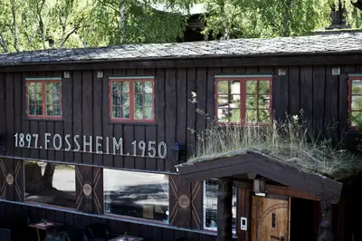 a small wooden house with some grass on it at Fossheim Hotel Lom in Lom