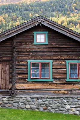 a log cabin with two windows on the side of it at Fossheim Hotel Lom in Lom
