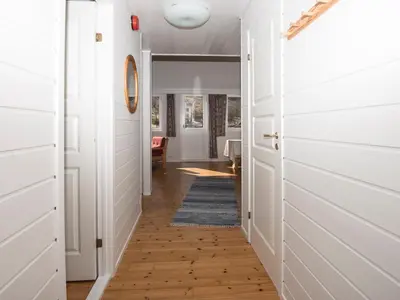 a hallway with white walls and wood floors at Grandane Feriehus in Stongfjorden