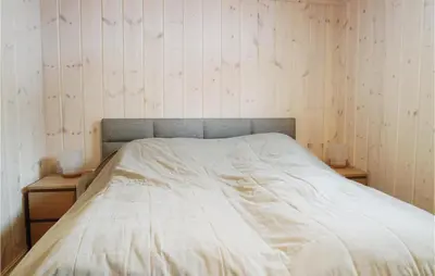 a bed in a bedroom with two nightstands and two lamps at Cozy Home In Lillehammer With Wifi in Lillehammer