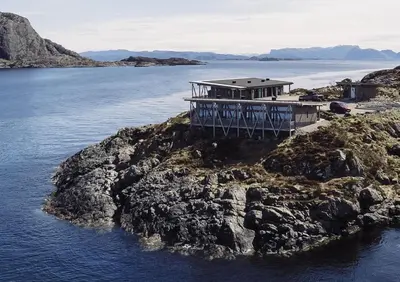 a house on an island in a body of water at Værlandet Havhotell in Hamna