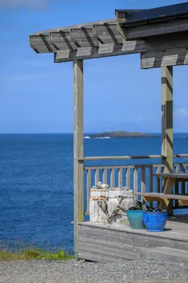 a wooden pergola with two blue bowls on a pier at Værlandet Havhotell in Hamna