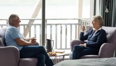 two women sitting in chairs in a living room at Værlandet Havhotell in Hamna