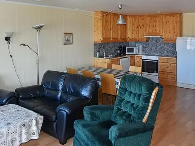 a living room with two leather couches and a kitchen at 6 person holiday home in Aukra in Aukra
