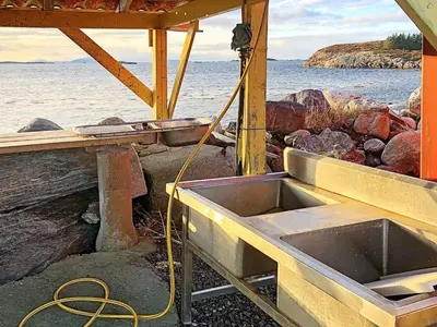 a sink in a building next to the water at 6 person holiday home in Aukra in Aukra