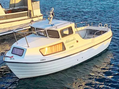 a white boat is docked in the water at 6 person holiday home in Aukra in Aukra