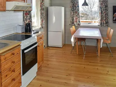 a kitchen with a table and a white refrigerator at 6 person holiday home in Aukra in Aukra