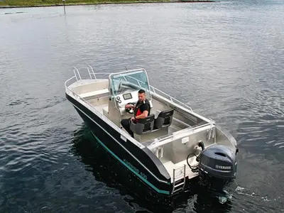 a man sitting in a boat on the water at 6 person holiday home in Aukra in Aukra