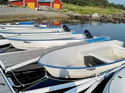 three boats are docked at a dock in the water at 6 person holiday home in Aukra in Aukra