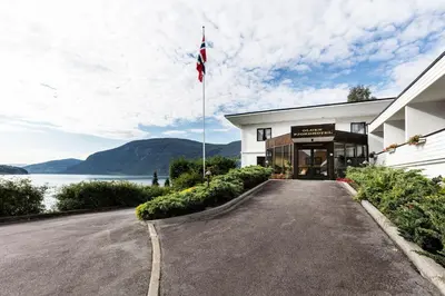 a building with a flag on the side of a road at Olden Fjordhotel in Olden