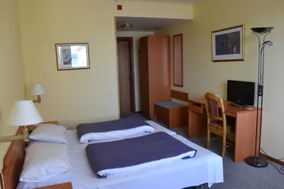 a hotel room with two beds and a desk at Midtnes Hotel in Balestrand