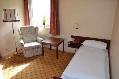 a hotel room with a bed and a chair and a desk at Midtnes Hotel in Balestrand