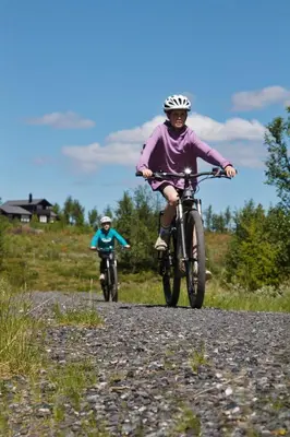 two people riding bikes down a dirt road at Oset Fjellhotell in Gol