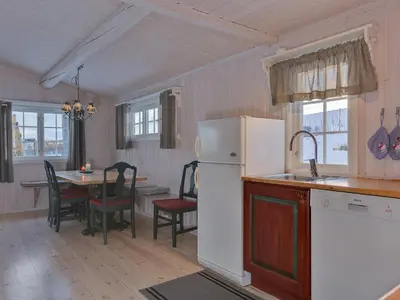 a kitchen with a refrigerator and a table with chairs at Gomobu Fjellstue in Ron