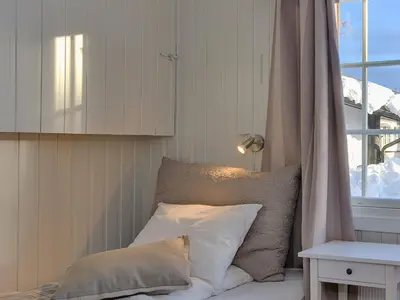 a bed with white pillows and a window in a room at Gomobu Fjellstue in Ron