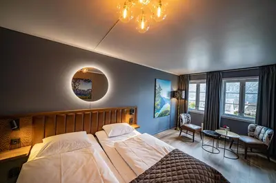 a bedroom with a large bed and a chandelier at Hotel Aurlandsfjord in Aurland
