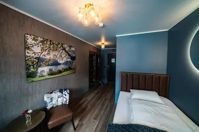 a bedroom with a bed and a table and a painting at Hotel Aurlandsfjord in Aurland