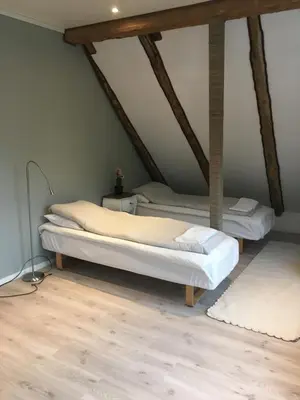 two beds in a room with wooden floors at Bakkevik Brygge in Kalvåg