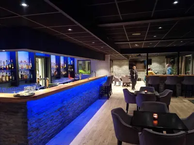 a bar with blue lighting in a restaurant at Bremanger Fjord Hotell in Svelgen