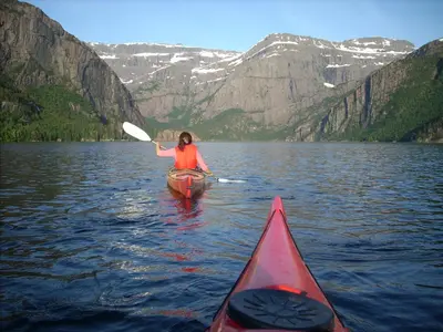 a woman in a kayak on a lake at Bremanger Fjord Hotell in Svelgen