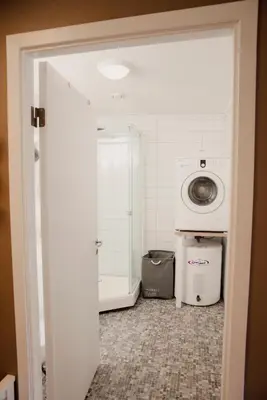 a laundry room with a washing machine and a washer at Åkrafjordtunet Apartments in Teigland