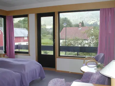 a bedroom with a bed and a large window at Innvik Fjordhotell in Innvik