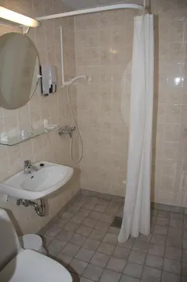 a bathroom with a shower and a sink and a toilet at Innvik Fjordhotell in Innvik