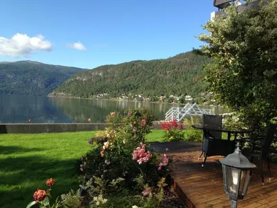 a deck with a bench and a view of a lake at Innvik Fjordhotell in Innvik