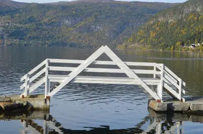 a white bridge in the water in a lake at Innvik Fjordhotell in Innvik