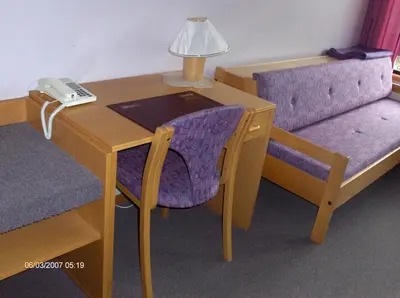 a desk with a phone next to a chair and a table at Innvik Fjordhotell in Innvik